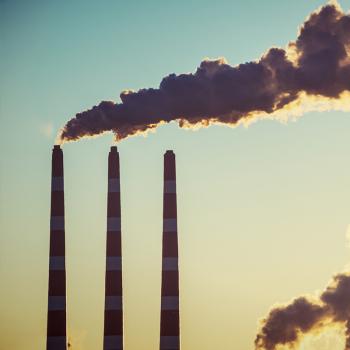 Chimneys bellowing smoke in the sunlight